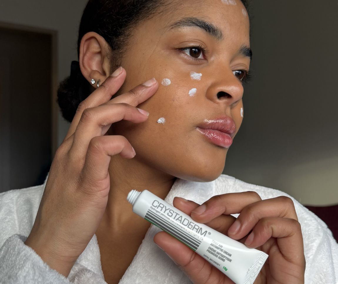 Femme appliquant la crème Crystaderm sur son visage